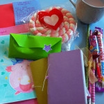 A photograph of a collection of colourful envelopes, handwritten letters and sweets against a blue background